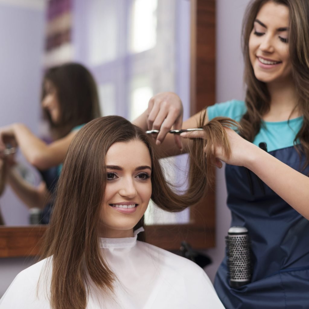 beautiful woman has cutting hair at the hairdresser