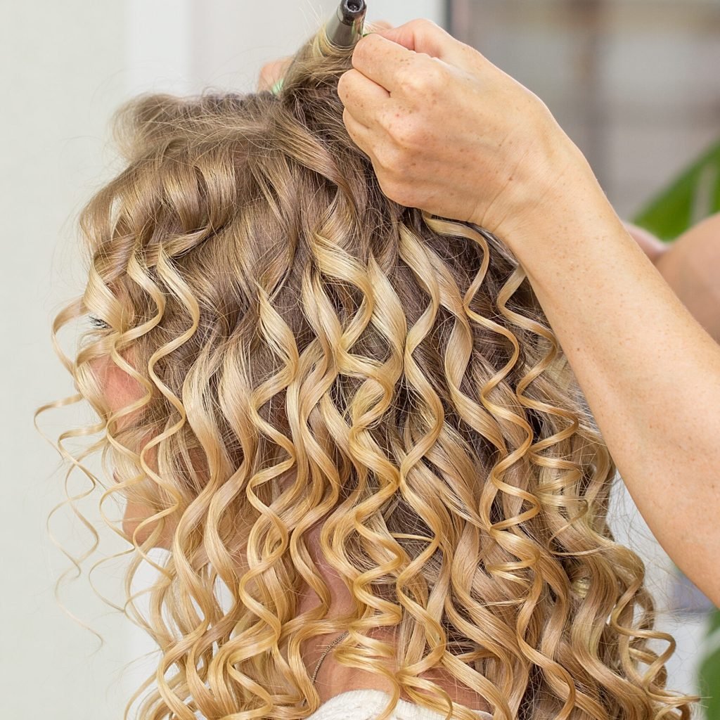 hair stylist makes the bride before wedding